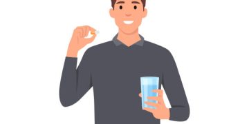 Young man cartoon standing and holding glass of water and pill capsule painkiller or vitamin medication in hands concept character . Flat vector illustration isolated on white background